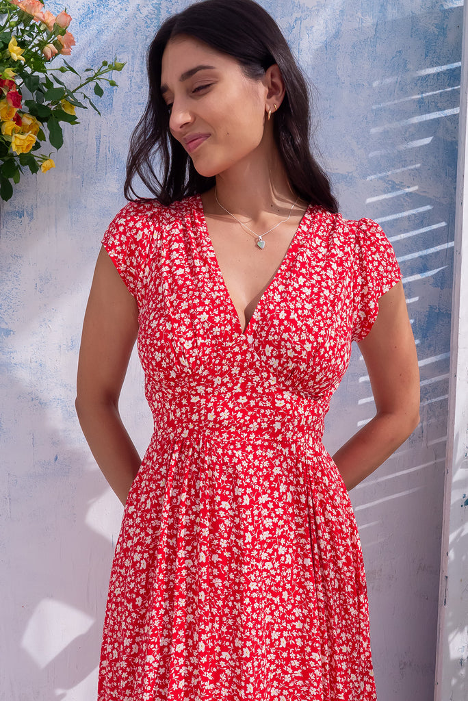 The Lizzie Red Ditzy Midi Dress is a gorgeous red midi dress with a white ditzy floral print. The dress features a Basque waist, feminine cut and gathered bust. Made from 100% rayon. 