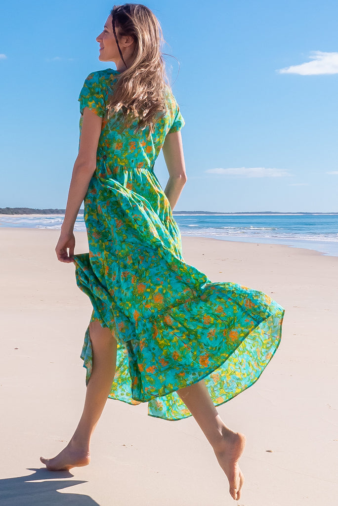 The Lucky Lulu Summer Blue Maxi Dress is a beautiful tiered maxi dress with a blue base and a green botanical print. This dress features a scooped neckline, adjustable waist tabs, side pockets and a wide tiered skirt. Made a woven blend of cotton and rayon.
