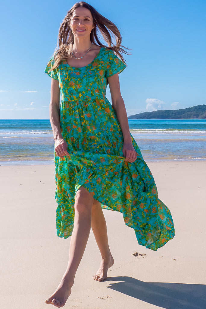 The Lucky Lulu Summer Blue Maxi Dress is a beautiful tiered maxi dress with a blue base and a green botanical print. This dress features a scooped neckline, adjustable waist tabs, side pockets and a wide tiered skirt. Made a woven blend of cotton and rayon.