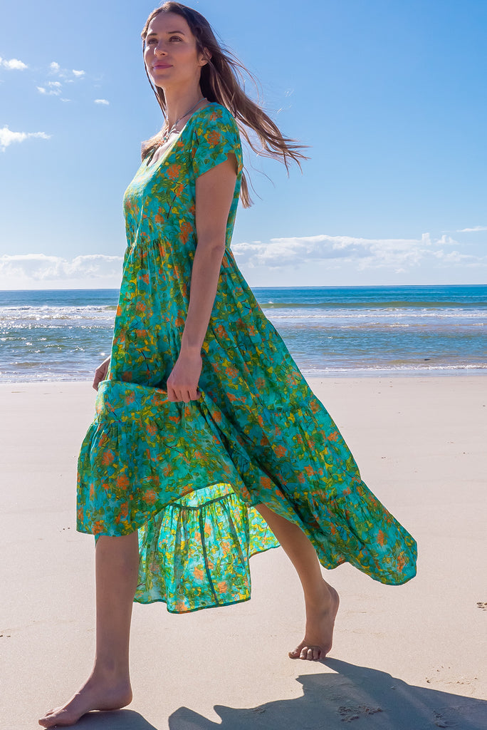 The Lucky Lulu Summer Blue Maxi Dress is a beautiful tiered maxi dress with a blue base and a green botanical print. This dress features a scooped neckline, adjustable waist tabs, side pockets and a wide tiered skirt. Made a woven blend of cotton and rayon.