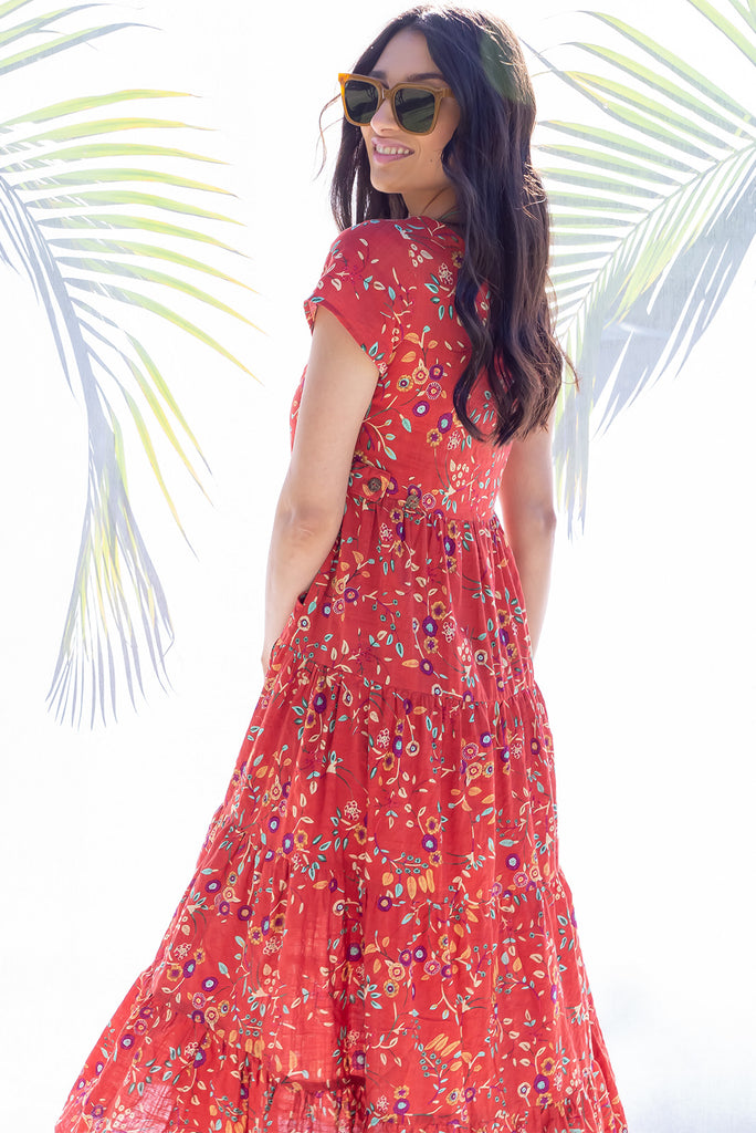 The Lucky Lulu Umbria Maxi Dress is a beautiful tiered maxi dress with a terracotta base and a floral leaf print. This dress features a scooped neckline, adjustable waist tabs, side pockets and a wide tiered skirt. Made a woven blend of cotton and rayon.
