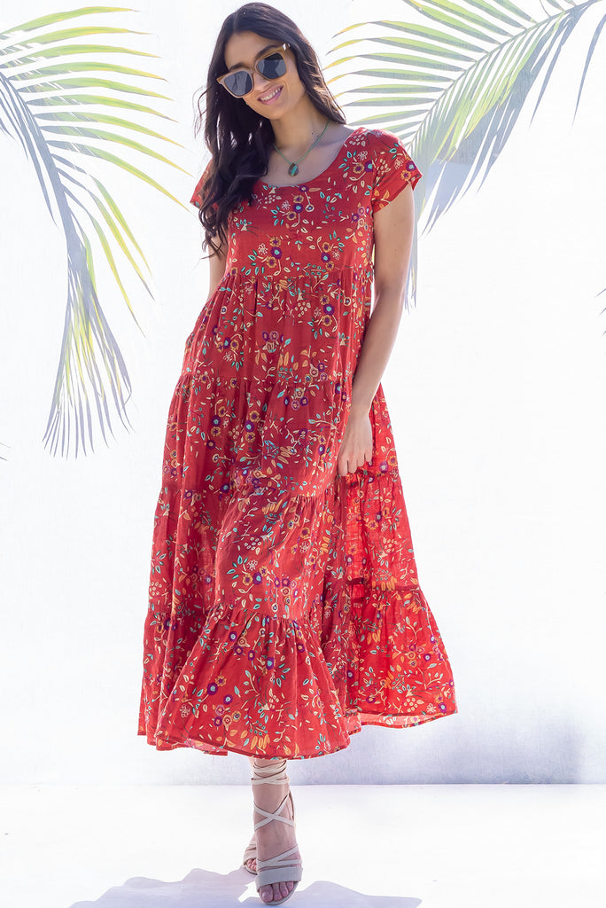 The Lucky Lulu Umbria Maxi Dress is a beautiful tiered maxi dress with a terracotta base and a floral leaf print. This dress features a scooped neckline, adjustable waist tabs, side pockets and a wide tiered skirt. Made a woven blend of cotton and rayon.