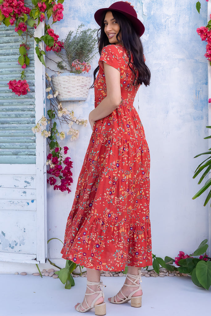 The Lucky Lulu Umbria Maxi Dress is a beautiful tiered maxi dress with a terracotta base and a floral leaf print. This dress features a scooped neckline, adjustable waist tabs, side pockets and a wide tiered skirt. Made a woven blend of cotton and rayon.