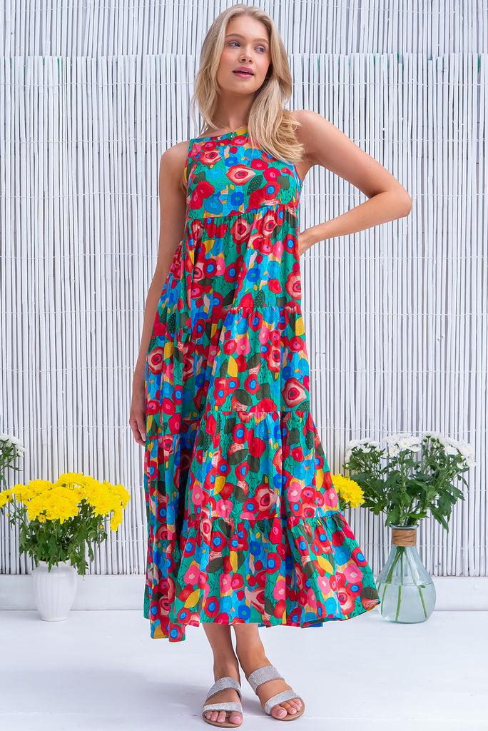 The Lulu Darling Green Floral Maxi Dress is a gorgeous green dress with a bright, multicoloured abstract floral print. The maxi dress features a high neck, high cut under the arms, full tiered skirt falling from under bust, side pockets, and is woven cotton/rayon blend. 