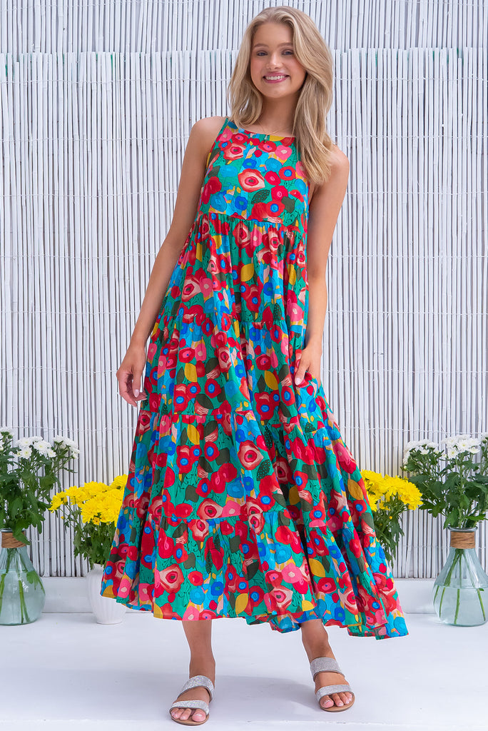 The Lulu Darling Green Floral Maxi Dress is a gorgeous green dress with a bright, multicoloured abstract floral print. The maxi dress features a high neck, high cut under the arms, full tiered skirt falling from under bust, side pockets, and is woven cotton/rayon blend. 