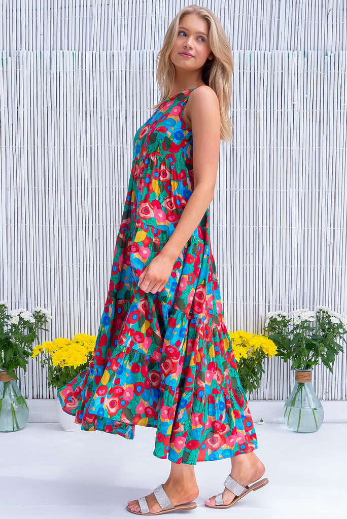 The Lulu Darling Green Floral Maxi Dress is a gorgeous green dress with a bright, multicoloured abstract floral print. The maxi dress features a high neck, high cut under the arms, full tiered skirt falling from under bust, side pockets, and is woven cotton/rayon blend. 