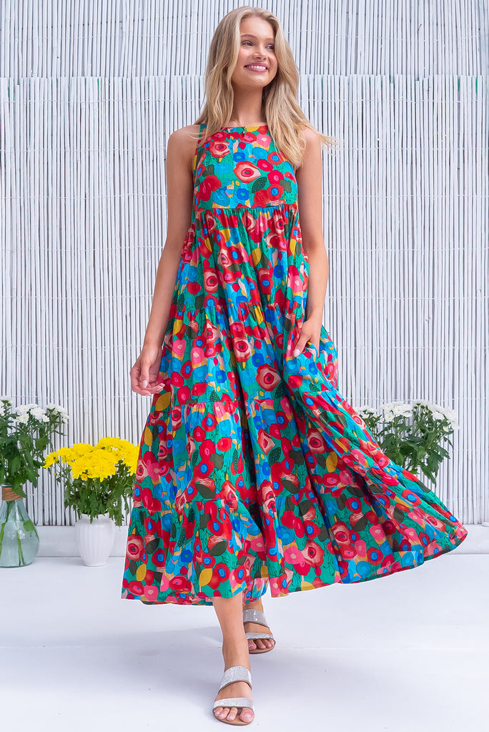 The Lulu Darling Green Floral Maxi Dress is a gorgeous green dress with a bright, multicoloured abstract floral print. The maxi dress features a high neck, high cut under the arms, full tiered skirt falling from under bust, side pockets, and is woven cotton/rayon blend. 