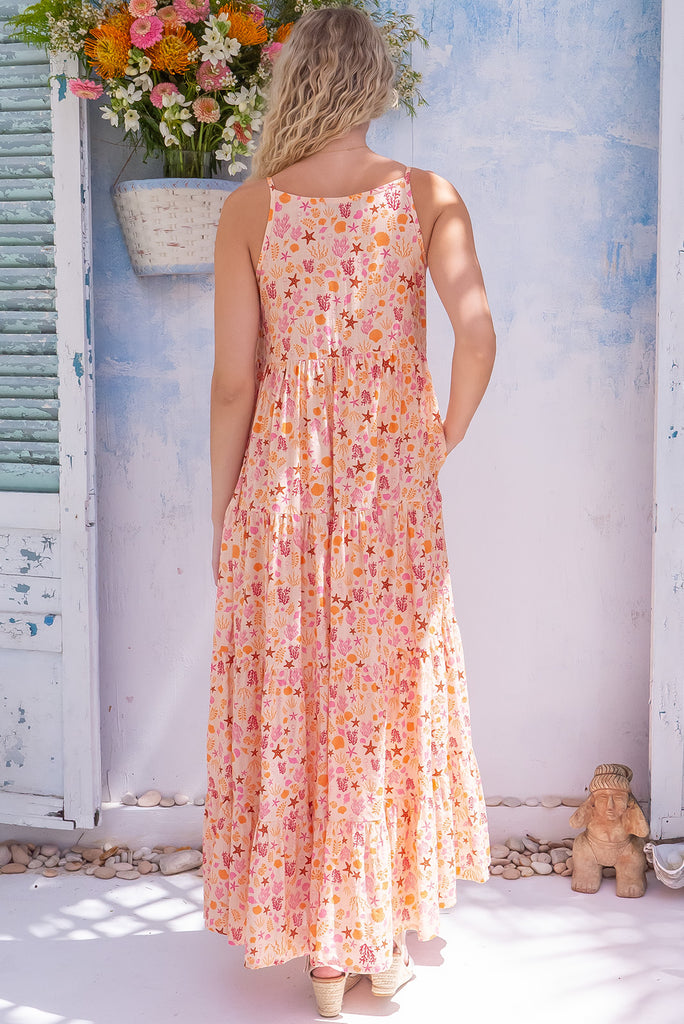 The Lulu Darling Seashell Sand Maxi Dress is a gorgeous cream based maxi dress with a small seashell print all over in warm tones. The maxi dress features a high neck, high cut under the arms, full tiered skirt falling from under bust, side pockets, and is made from a woven cotton/rayon blend. 
