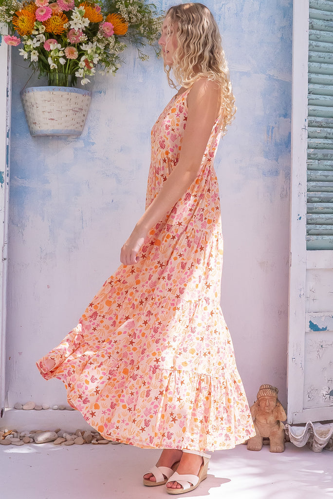 The Lulu Darling Seashell Sand Maxi Dress is a gorgeous cream based maxi dress with a small seashell print all over in warm tones. The maxi dress features a high neck, high cut under the arms, full tiered skirt falling from under bust, side pockets, and is made from a woven cotton/rayon blend. 