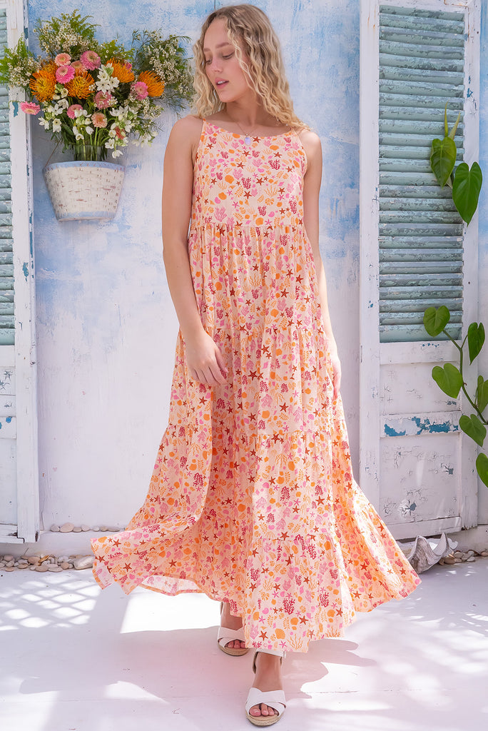 The Lulu Darling Seashell Sand Maxi Dress is a gorgeous cream based maxi dress with a small seashell print all over in warm tones. The maxi dress features a high neck, high cut under the arms, full tiered skirt falling from under bust, side pockets, and is made from a woven cotton/rayon blend. 