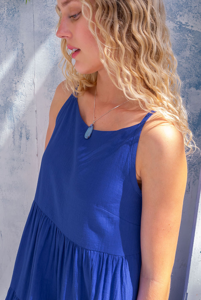 The Lulu Ric Rac Cobalt Maxi Dress is a beautiful blue maxi dress with a white oversized ric-rac braid feature. The maxi dress features a high neck, high cut under the arms, full tiered skirt falling from under bust, ric-rac on bottom three tiers, side pockets, and is made from woven cotton. 