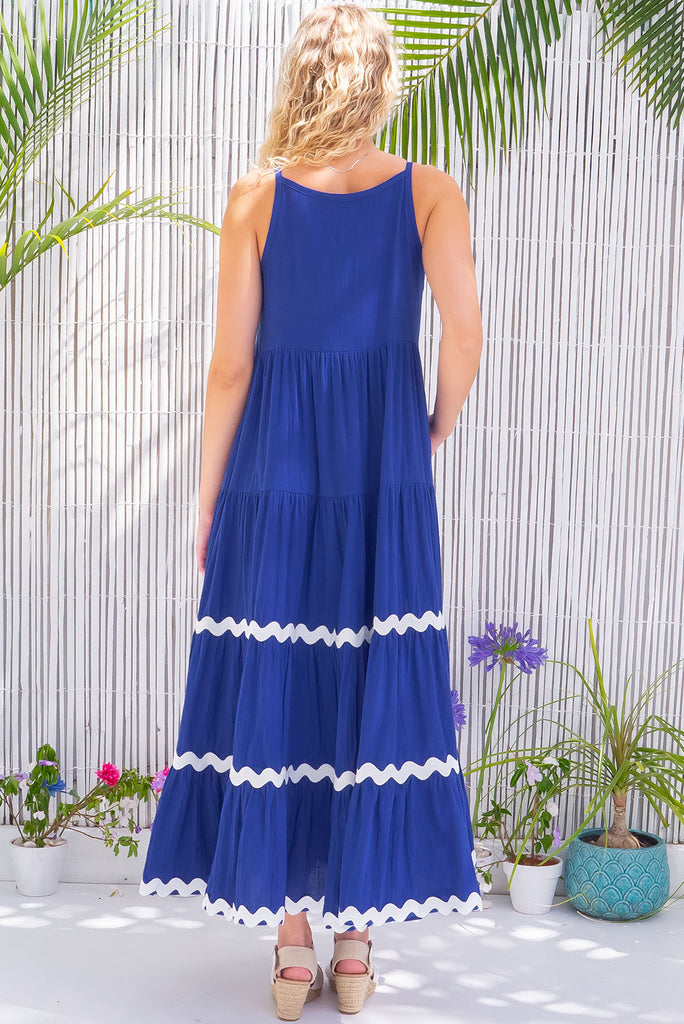 The Lulu Ric Rac Cobalt Maxi Dress is a beautiful blue maxi dress with a white oversized ric-rac braid feature. The maxi dress features a high neck, high cut under the arms, full tiered skirt falling from under bust, ric-rac on bottom three tiers, side pockets, and is made from woven cotton. 