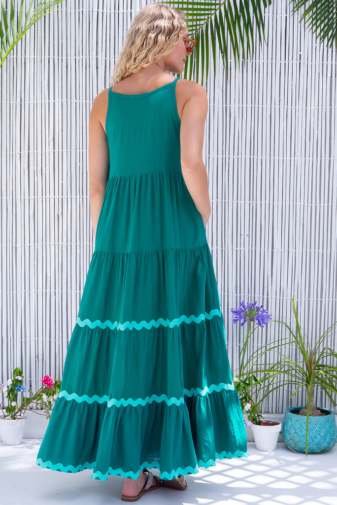 The Lulu Ric Rac Jade Maxi Dress is a gorgeous jade green maxi dress with a pastel green oversized ric-rac braid feature. The maxi dress features a high neck, high cut under the arms, full tiered skirt falling from under bust, ric-rac on bottom three tiers, side pockets, and is made from woven cotton. 