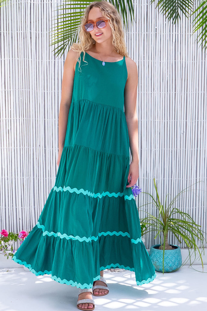 The Lulu Ric Rac Jade Maxi Dress is a gorgeous jade green maxi dress with a pastel green oversized ric-rac braid feature. The maxi dress features a high neck, high cut under the arms, full tiered skirt falling from under bust, ric-rac on bottom three tiers, side pockets, and is made from woven cotton. 