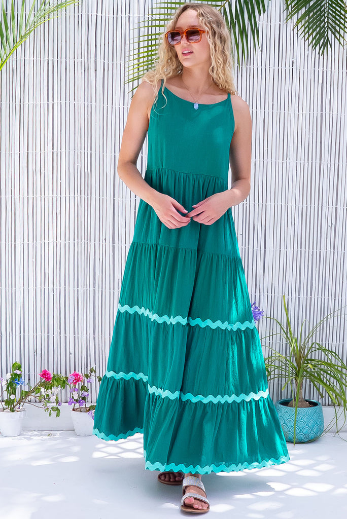 The Lulu Ric Rac Jade Maxi Dress is a gorgeous jade green maxi dress with a pastel green oversized ric-rac braid feature. The maxi dress features a high neck, high cut under the arms, full tiered skirt falling from under bust, ric-rac on bottom three tiers, side pockets, and is made from woven cotton. 
