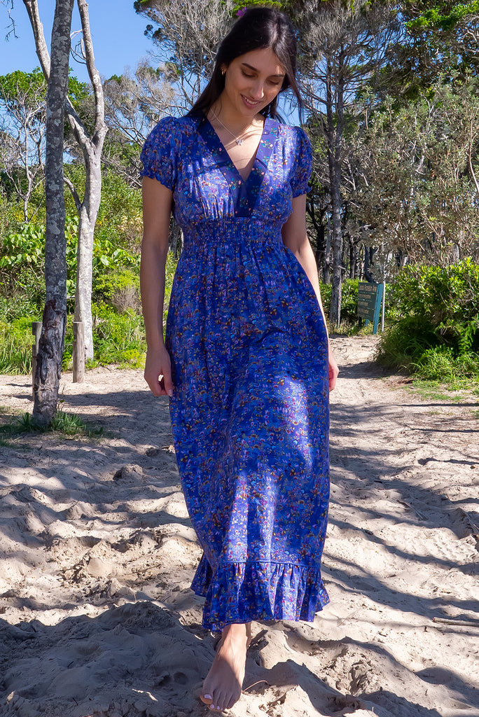 The Moonshadow Blur Maxi Dress is a beautiful periwinkle blue based dress with a floral print. The dress features a mixed print on the neckline panel, short sleeves, v-neckline with hidden bust fastening, elasticated empire line, tie at the back of the neck, and side pockets. Made from a woven blend of cotton and rayon.