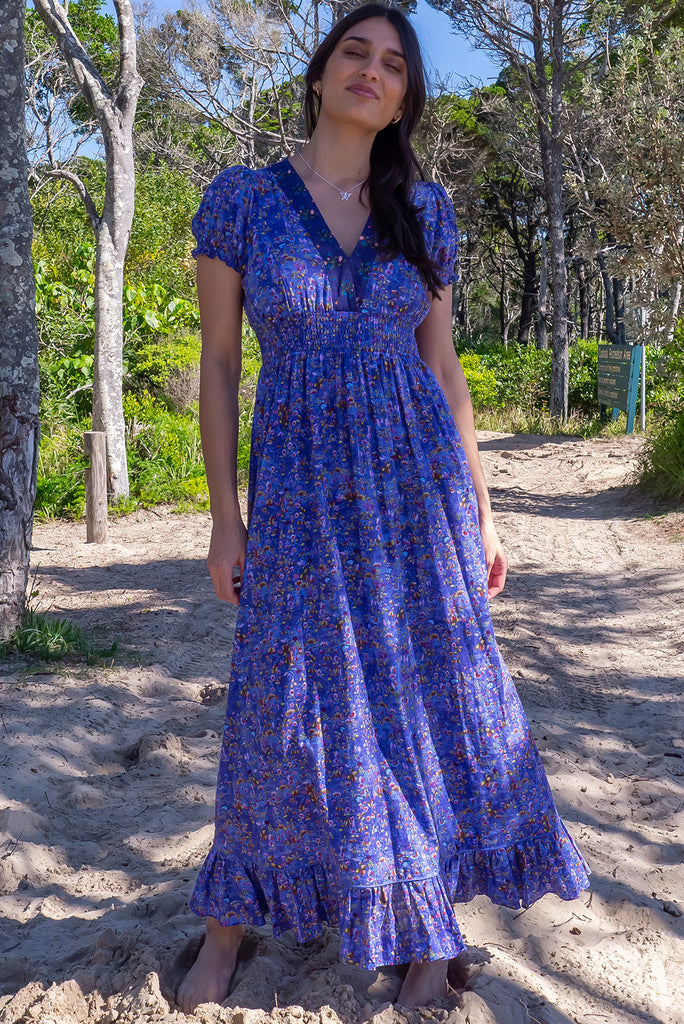 The Moonshadow Blur Maxi Dress is a beautiful periwinkle blue based dress with a floral print. The dress features a mixed print on the neckline panel, short sleeves, v-neckline with hidden bust fastening, elasticated empire line, tie at the back of the neck, and side pockets. Made from a woven blend of cotton and rayon.