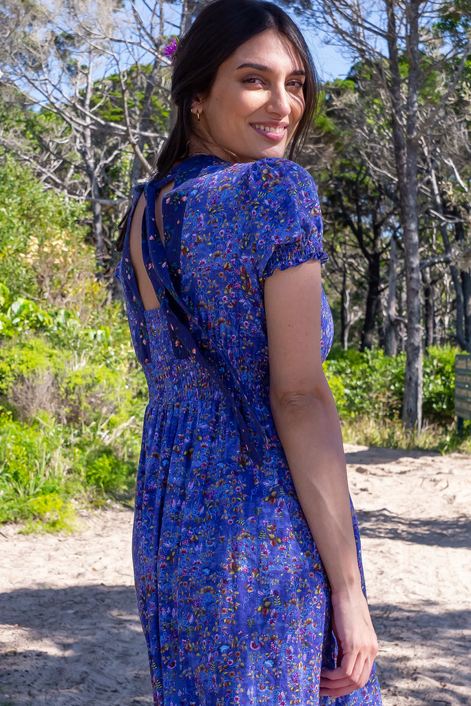 The Moonshadow Blur Maxi Dress is a beautiful periwinkle blue based dress with a floral print. The dress features a mixed print on the neckline panel, short sleeves, v-neckline with hidden bust fastening, elasticated empire line, tie at the back of the neck, and side pockets. Made from a woven blend of cotton and rayon.