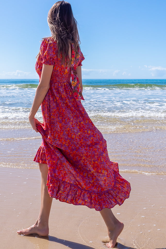 The Moonshadow Pink Spice Maxi Dress is a gorgeous pink based dress with a floral print. The dress features a mixed print on the neckline panel, short sleeves, v-neckline with hidden bust fastening, elasticated empire line, tie at the back of the neck, and side pockets. Made from a woven blend of cotton and rayon.