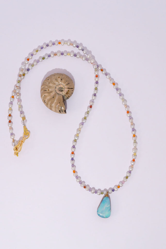 This delicate necklace hides a tiny shimmer of pastel colour between each soft white pearl. The beautiful Australian Boulder Opal pendant has lovely flashes of blue & green.