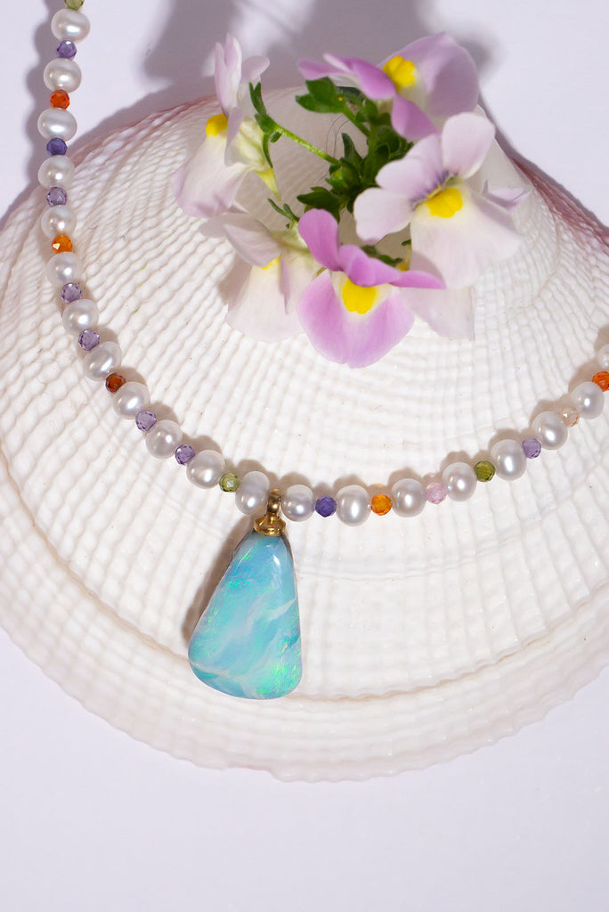 This delicate necklace hides a tiny shimmer of pastel colour between each soft white pearl. The beautiful Australian Boulder Opal pendant has lovely flashes of blue & green.