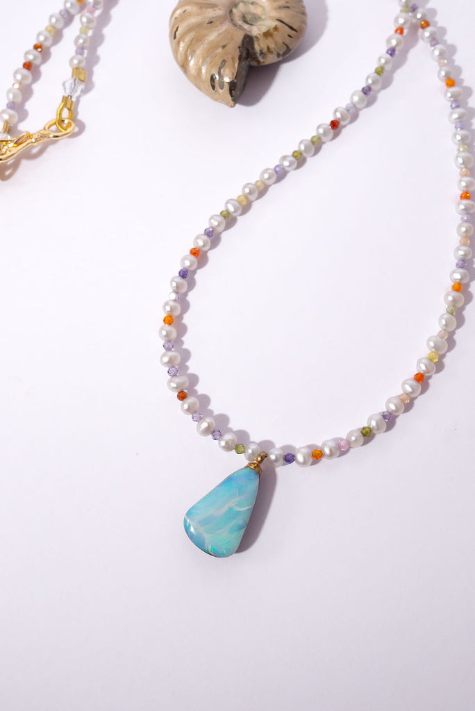 This delicate necklace hides a tiny shimmer of pastel colour between each soft white pearl. The beautiful Australian Boulder Opal pendant has lovely flashes of blue & green.