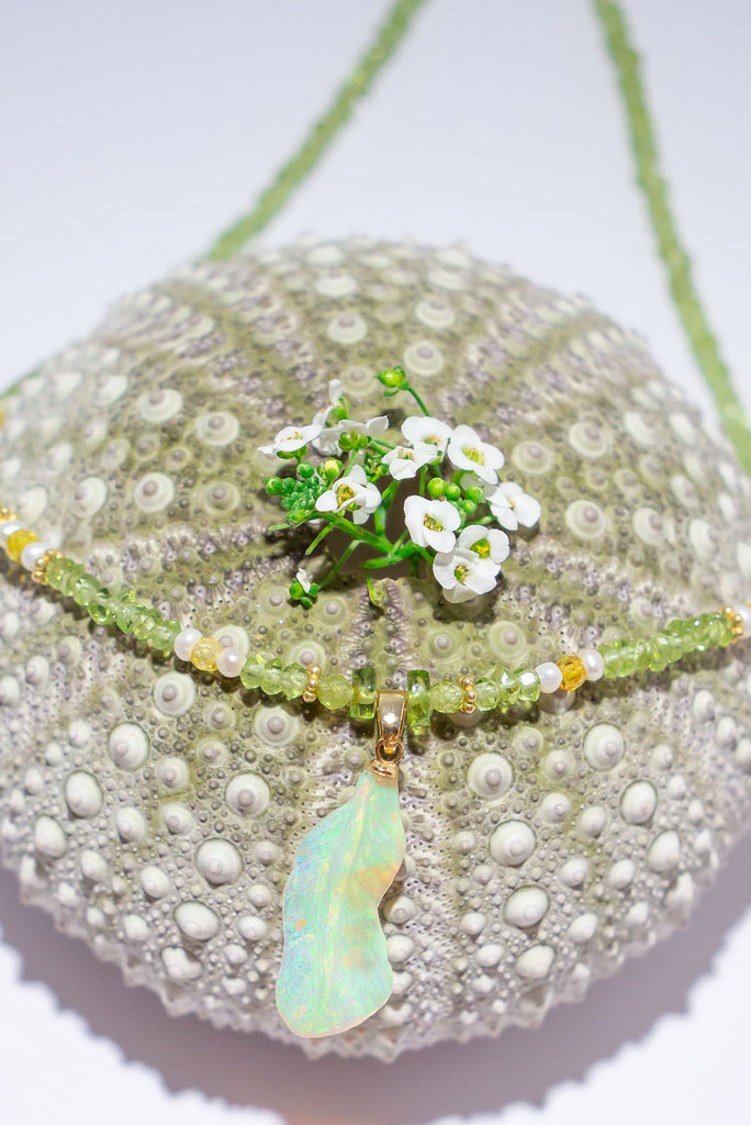 Feel the magic of this beautiful crystal opal carved into a feather, glowing green, blue, pink and gold this ethereal piece comes on a necklace of soft green Peridot beads with Citrine and pearl highlights.