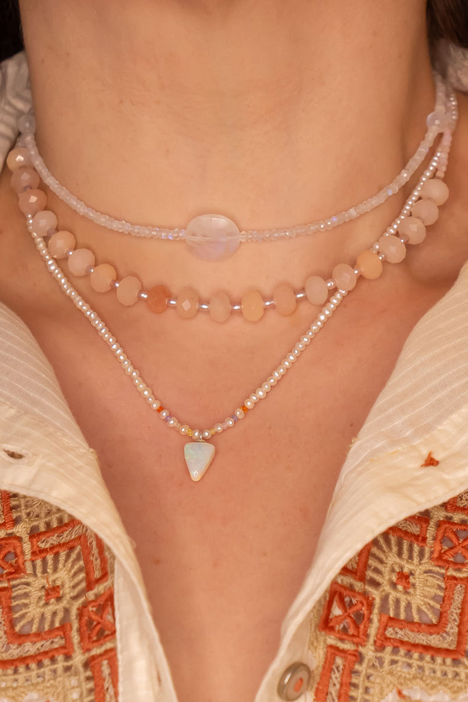 A pearl necklace with twist, we have added a tiny luminous crystal opal as the centrepiece.