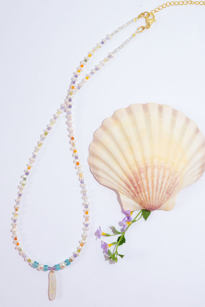 Like a rainbow of water droplets, this Australian Mintabie Opal flashes gold, deep pink and green, tiny pearls interspaced with sparkling faceted gemstone beads on the necklace.