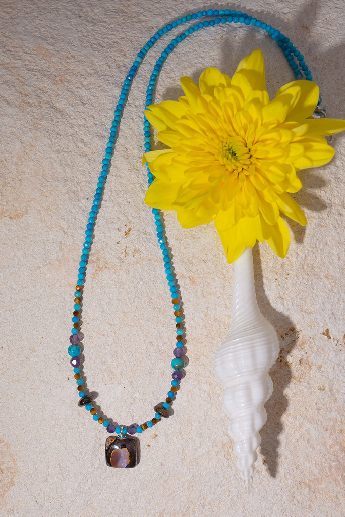 Pretty, modern and sparkly, a tiny opal is the centrepiece on a bright multi stone bead gemstone necklace that glitters in the light.