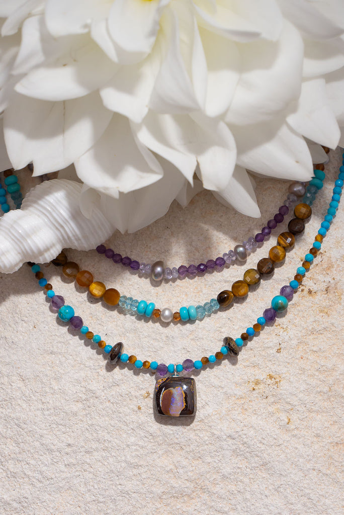 Pretty, modern and sparkly, a tiny opal is the centrepiece on a bright multi stone bead gemstone necklace that glitters in the light.