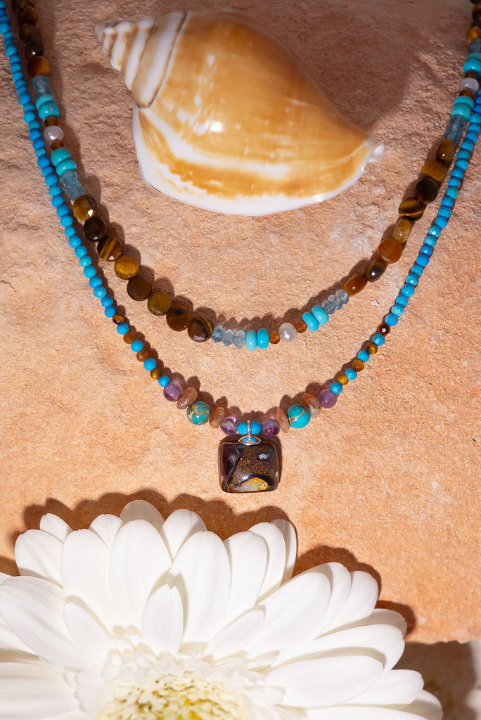 Pretty, modern and sparkly, a tiny opal is the centrepiece on a bright multi stone bead gemstone necklace that glitters in the light.