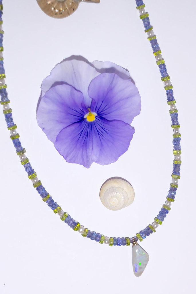 The unusual and captivating combination of Tanzanite and Peridot is the perfect reflection of the colour play in this necklaces stunning Mintabie Opal pendant.