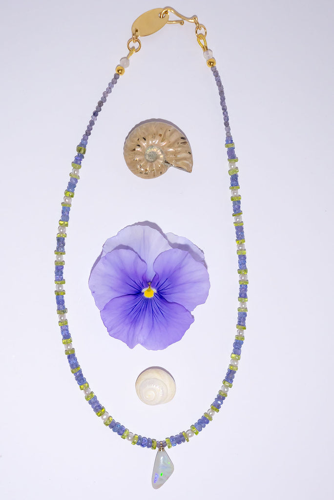 The unusual and captivating combination of Tanzanite and Peridot is the perfect reflection of the colour play in this necklaces stunning Mintabie Opal pendant.
