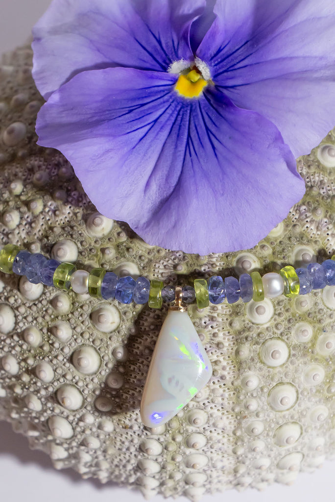 The unusual and captivating combination of Tanzanite and Peridot is the perfect reflection of the colour play in this necklaces stunning Mintabie Opal pendant.