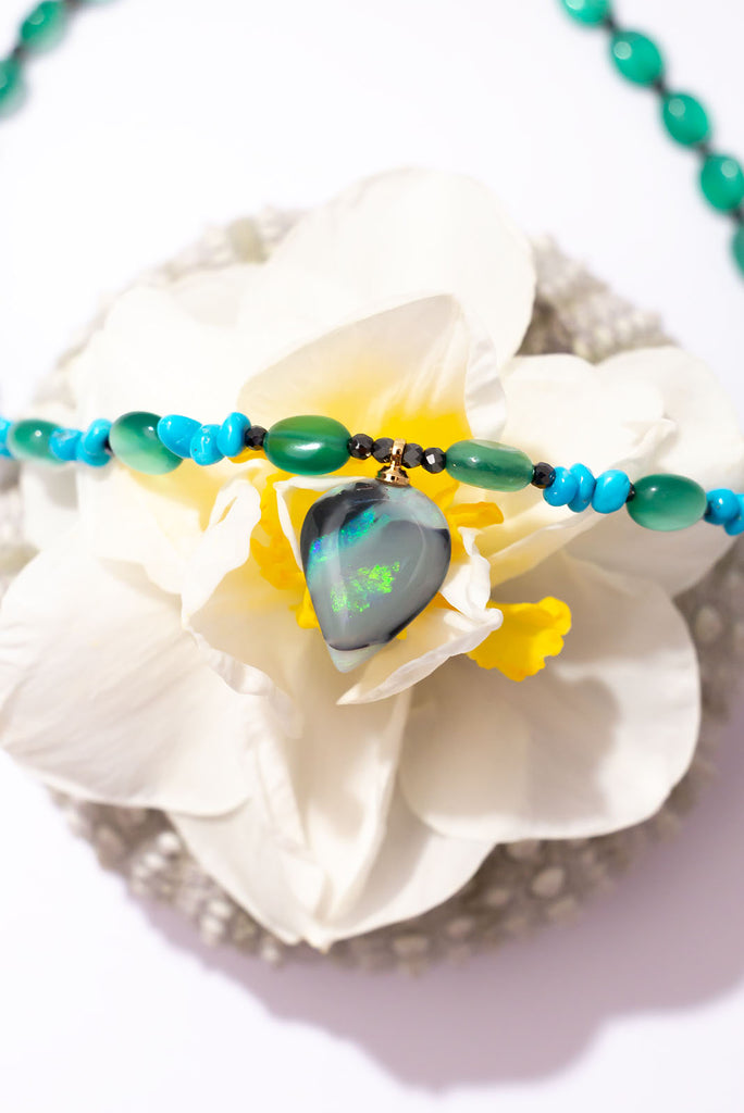 With gorgeous bubbles of green onyx, intense sky-blue Sleeping Beauty turquoise and a luminous black opal with shimmering streaks of green and aqua colour play this is a truly enchanting piece.