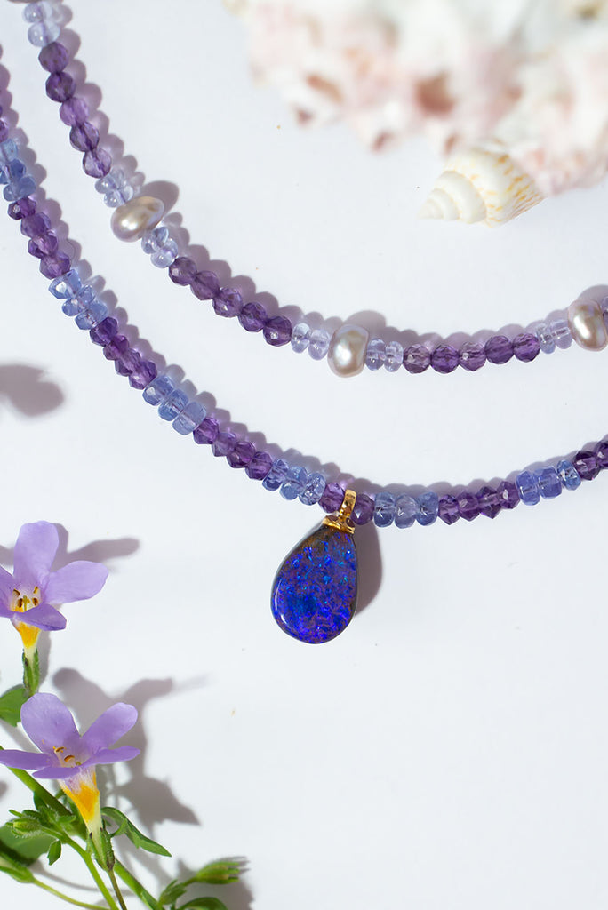 This magical pendant sparkles with blue flashes in a beautiful purple pool of opal. The stunning combination of amethyst & tanzanite is the perfect reflection of the opals shimmering colours.
