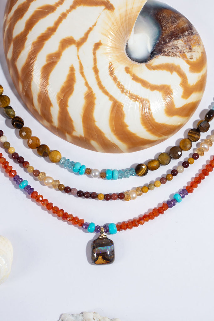 This delicate gemstone necklace features showing stopping jewel tones and a petite boulder opal pendant.