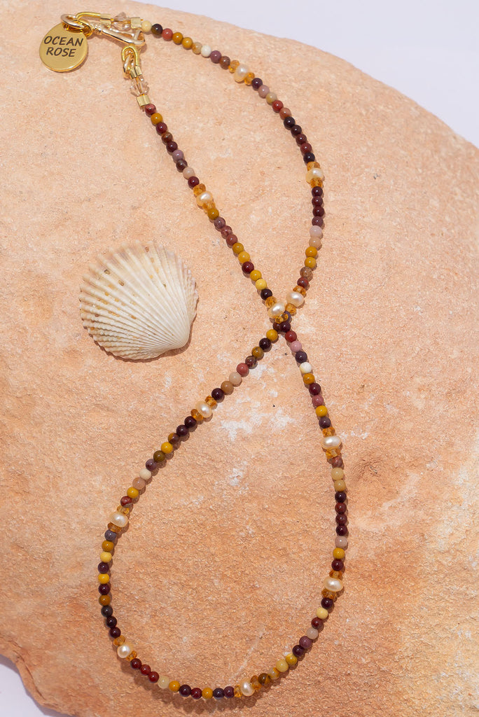 A delicate strand of earthy natural toned gemstones and shimmering deep cream pearls.