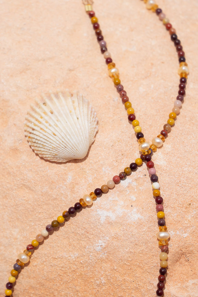 A delicate strand of earthy natural toned gemstones and shimmering deep cream pearls.