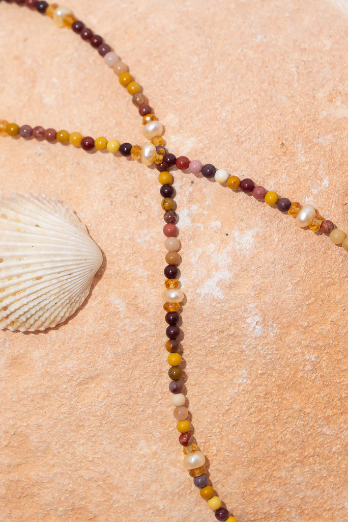 A delicate strand of earthy natural toned gemstones and shimmering deep cream pearls.