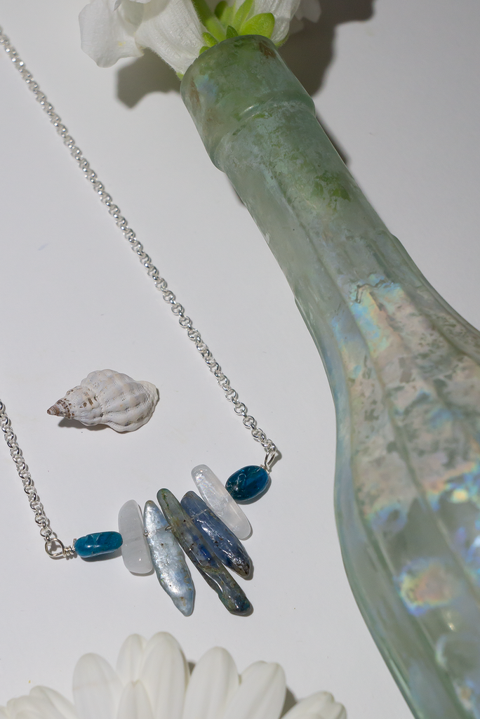 The swing style necklace is designed in a simple and chic style, using rough shards of the semi precious stone Kyanite.