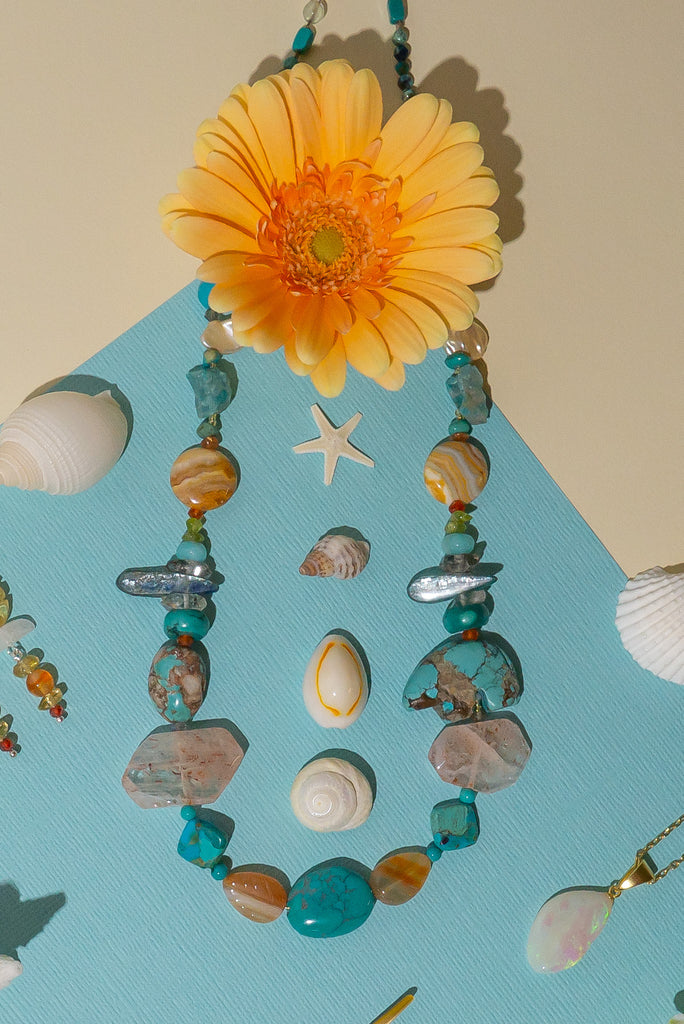 The necklace features a hand carved Zuni bears bought in Taos new Mexico. Stones are Natural Turquoise, Herkimer Diamond, Kyanite rough shards, Pearl, natural Sunstone, Strawberry Quartz, Banded Agate, Peridot and Labradorite .