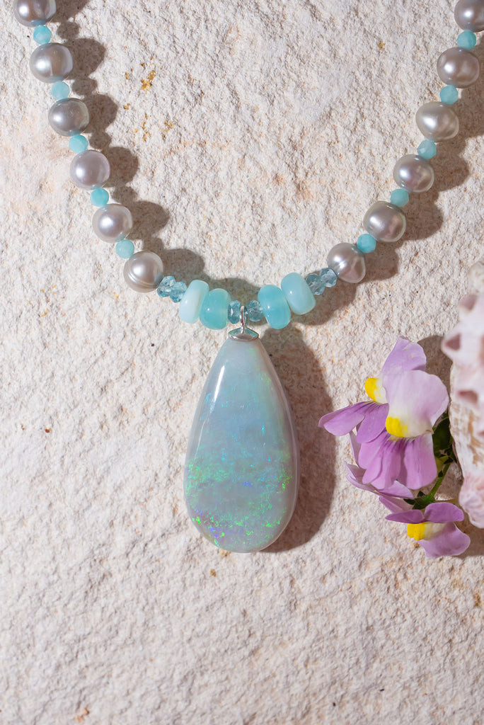 Like the colour of a wave as it turns, a crystal opal with tiny sparkle flashes of green and blue, on a necklace of small lustrous silver grey pearls with Amazonite highlights.
