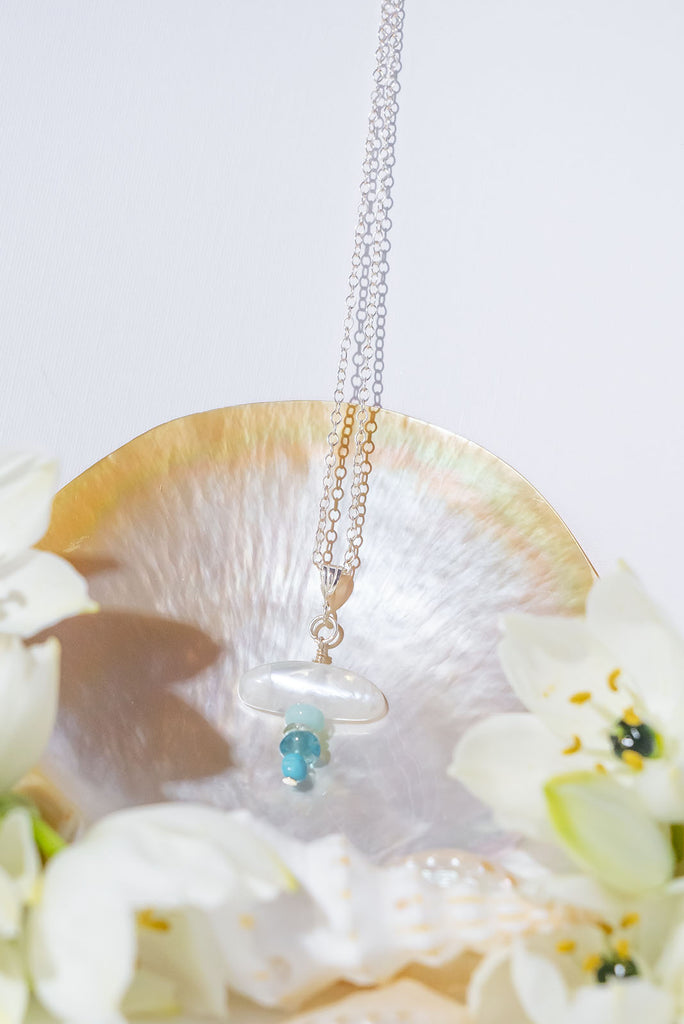 The Necklace Precious Droplet Moonstone Blues is a delicately precious, naturally sourced, handmade moonstone gemstone necklace with 925 sterling silver chain and findings. It is a natural moonstone droplet with Peruvian opal, prasiolite , apatite, and Kingman Turquoise.