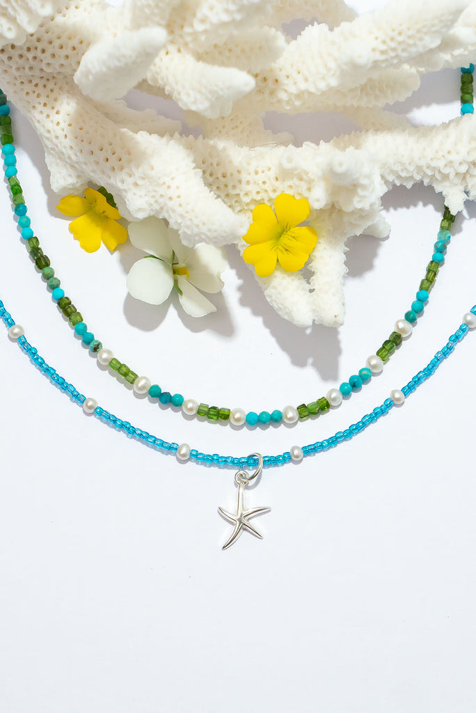 This dainty necklace embodies the seaside in the Summer months. Sparkling blues, soft luminescent white and a shimmer silver starfish.