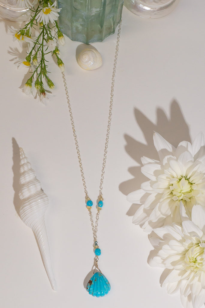 The perfect style for lovers of the sea. This beautiful handmade necklace features a delicate carved turquoise scallop shell pendant.