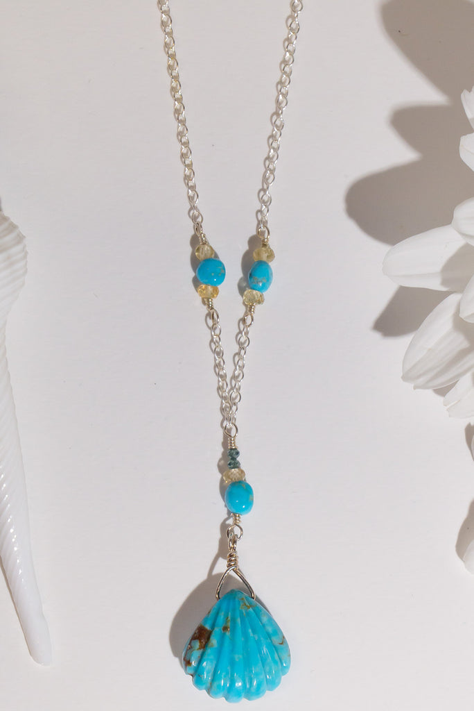 The perfect style for lovers of the sea. This beautiful handmade necklace features a delicate carved turquoise scallop shell pendant.