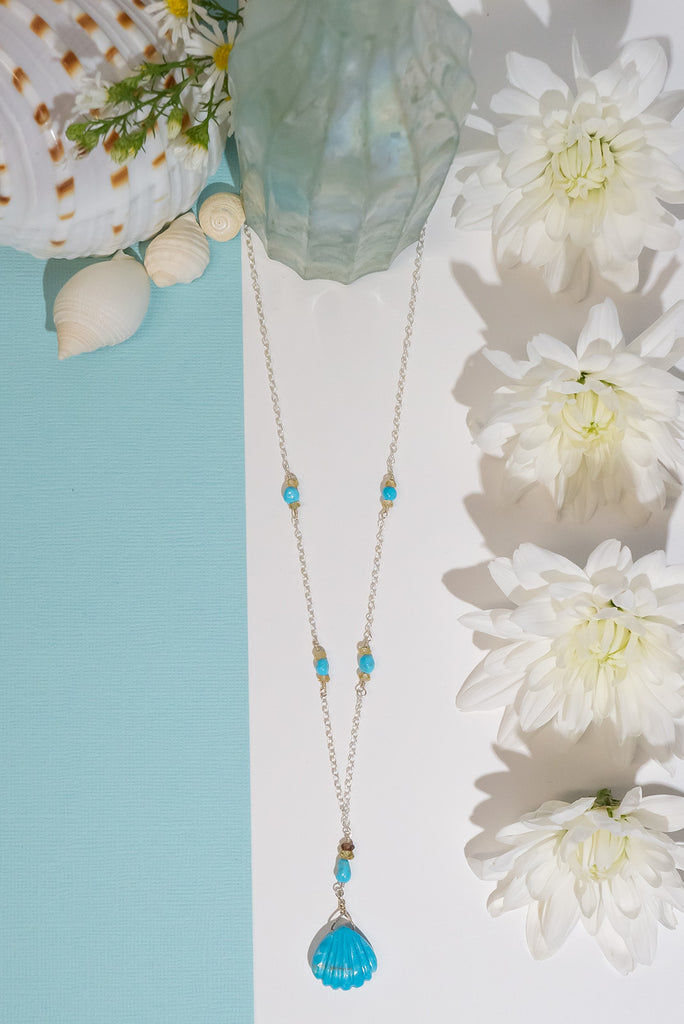 We've fallen in love with turquoise. This beautiful handmade necklace features a delicate carved turquoise scallop shell pendant.