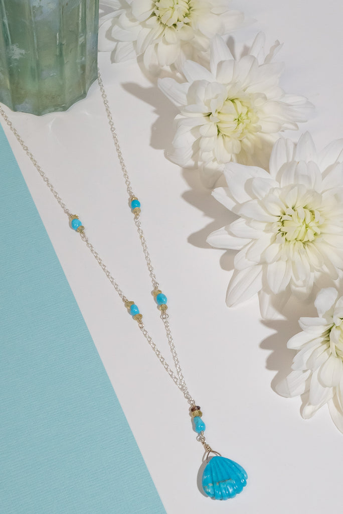 We've fallen in love with turquoise. This beautiful handmade necklace features a delicate carved turquoise scallop shell pendant.